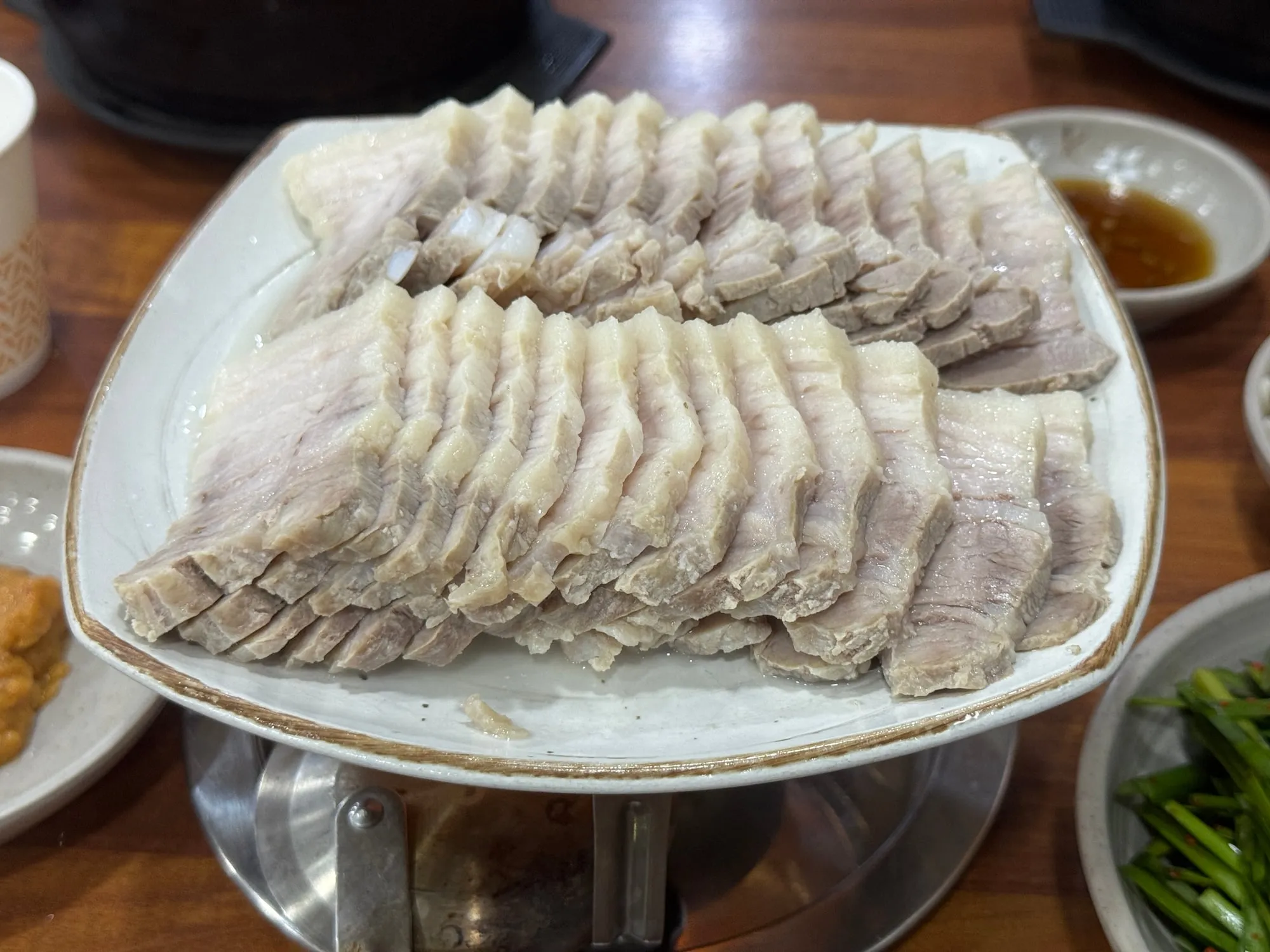 워머 위에 정갈하게 담긴 수육과 부추무침