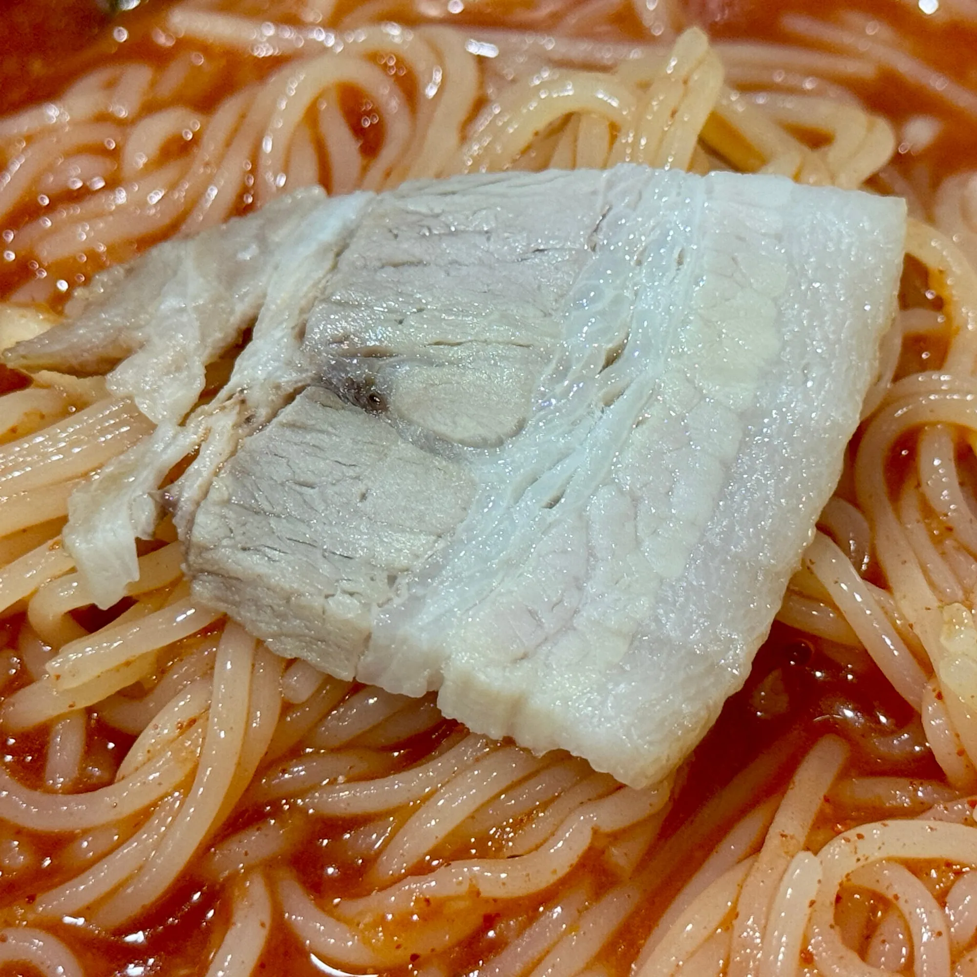 비빔 양념 위에 수육 한 점이 올라간 면