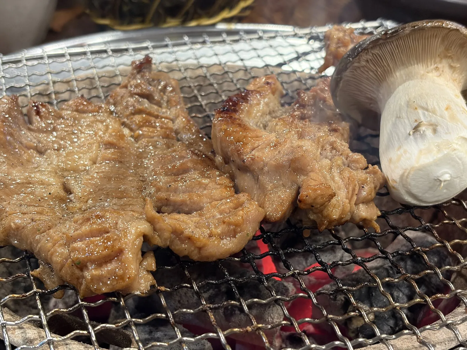 숯불 위에서 지글지글 익는 돼지갈비와 새송이버섯