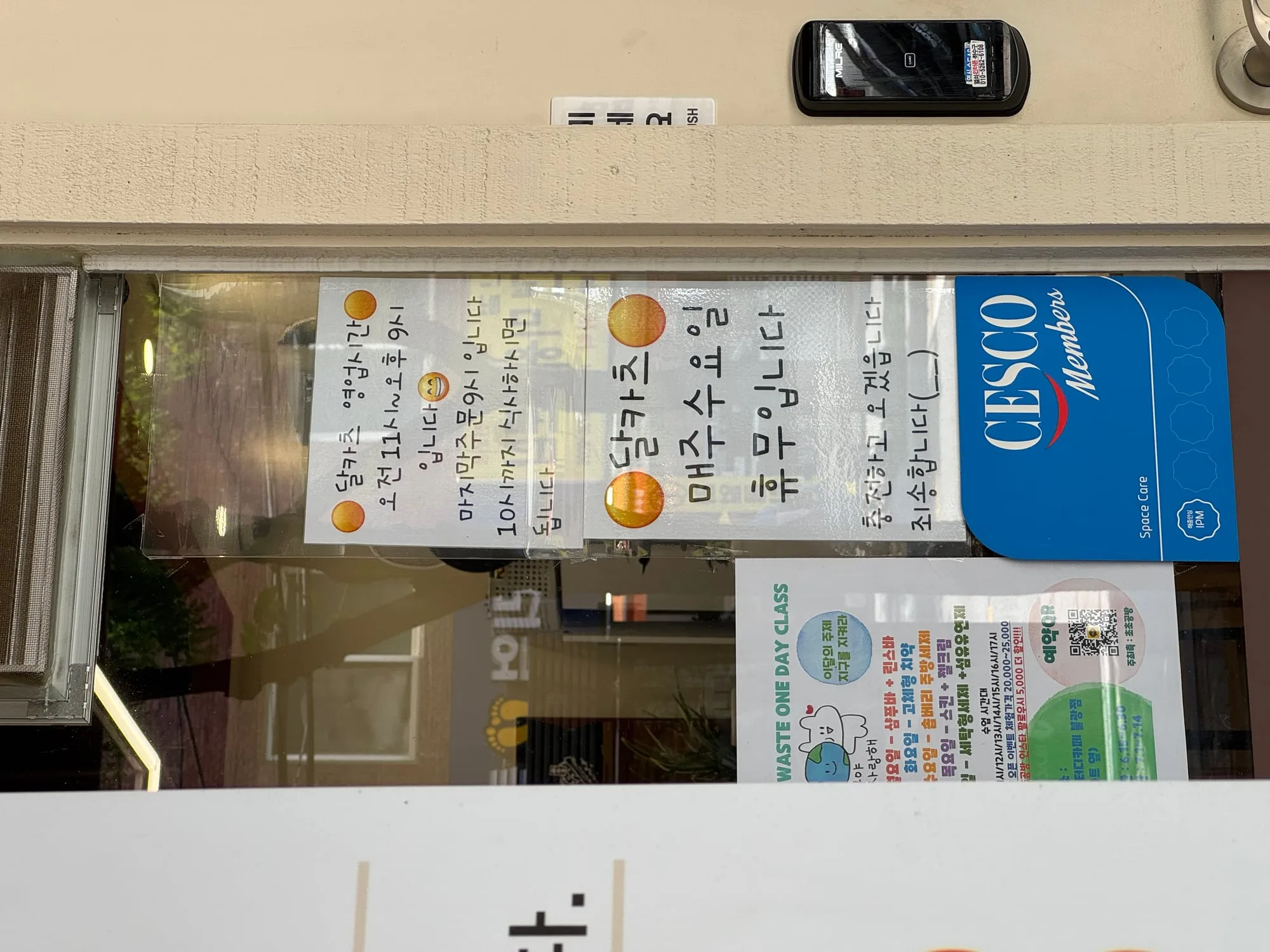 가게 유리문에 붙은 영업시간 안내문