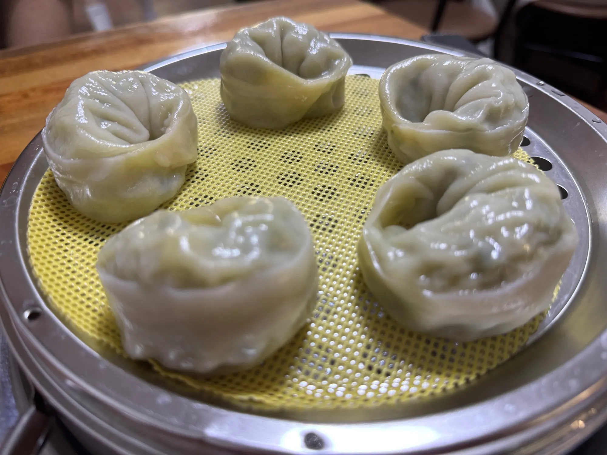 스테인리스 찜기 위에 놓인 찐만두 5알